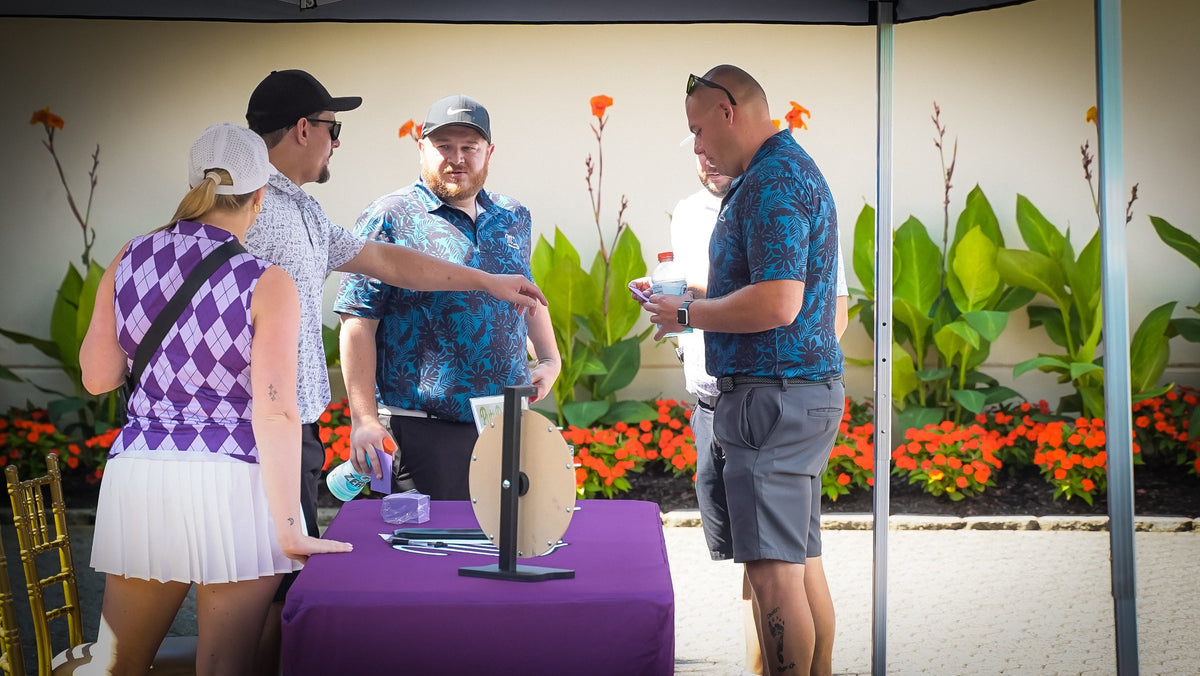 Golfers gathering around a raffle game at Swing For A Cure
